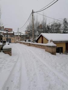 a snow covered street with snow covered roofs and buildings at Apartamentos Rurales Camino del Cid in Castejón de las Armas