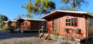 a small cabin with a porch and a playground at Trangie Caravan Park in Trangie
