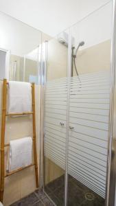 La salle de bains est pourvue d'une douche avec une porte en verre. dans l'établissement Mayer 8 Hotel By Peraia, à Tel Aviv