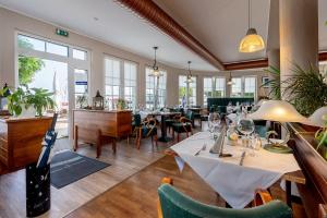 a restaurant with tables and chairs and windows at Sur la Mer - Pension Garni in Barth