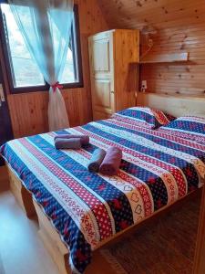 een slaapkamer met een bed in een houten hut bij VILLA KORANA in Barilović