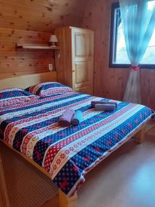 a bed in a cabin with a quilt on it at VILLA KORANA in Barilović