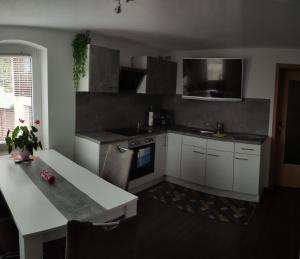 a kitchen with white cabinets and a table and a sink at Ferienwohnung Berger 