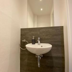 a white sink in a bathroom with a mirror at über den Dächern von Neheim I in Arnsberg +29 photos