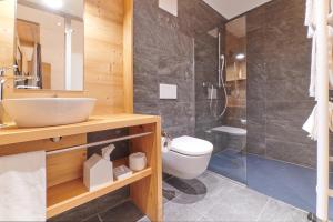 a bathroom with a sink and a toilet and a shower at Boutique Hotel Beau-Séjour & Spa Superior in Champéry +57 photos