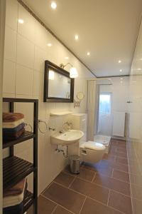 bagno con lavandino, servizi igienici e specchio di Das Märchenhaus a Braunlage