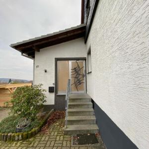 a stairway leading to a white building with a door at über den Dächern von Neheim in Arnsberg