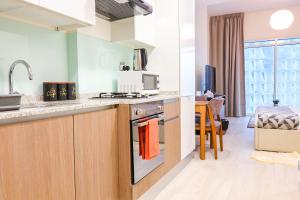 a kitchen with a sink and a stove top oven at SHH - Furnished Studio Apartment in Azizi Aliyah Residences, Al Jaddaf in Dubai