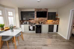 a kitchen with black appliances and a white table at Bright and Luxurious Flat in the Heart of Reading in Reading