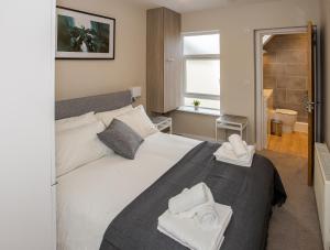 a bedroom with a bed with towels on it at Bright and Luxurious Flat in the Heart of Reading in Reading
