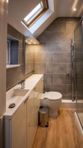 bagno con servizi igienici, lavandino e lucernario. di Bright and Luxurious Flat in the Heart of Reading a Reading