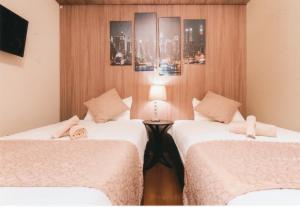 Habitación de hotel con 2 camas y mesa en Sakura Sands Hotel en Osaka