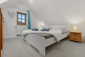 ein Schlafzimmer mit einem weißen Bett und einem Fenster in der Unterkunft TTP Apartments Immenstaad in Immenstaad am Bodensee