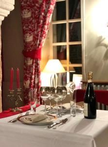 a table with a bottle of wine and wine glasses at Domaine de L'orangerie du château de Motteville chambres d'hotes in Motteville