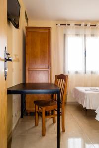 a black table and a chair in a room at El Roble Hotel Restaurante in Tábara