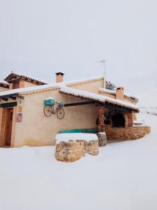 uma casa com uma bicicleta ao lado dela em Casa rural La Antigua Vaqueria em Aguilera