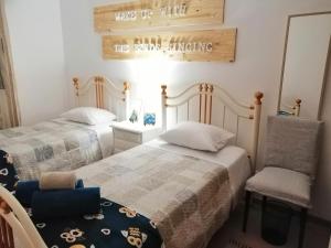 1 dormitorio con 2 camas, 1 silla y 1 cartel en Hilltop Azores - Beach & Countryside, en Porto Formoso