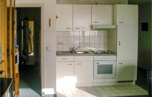 uma cozinha com armários brancos, um lavatório e um fogão em Awesome Apartment In Insel Poel With Harbor View em Insel Poel