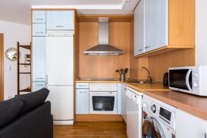 eine Küche mit einem weißen Kühlschrank und einer Mikrowelle in der Unterkunft Piso en c/ Casta Álvarez in Saragossa