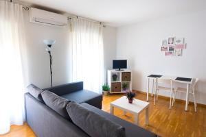 ein Wohnzimmer mit einem Sofa und einem Tisch in der Unterkunft Piso en c/ Casta Álvarez in Saragossa
