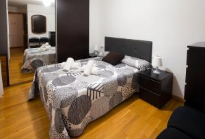 1 dormitorio con cama y espejo grande en Piso en c/ Casta Álvarez, en Zaragoza