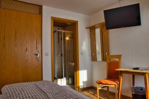 um quarto com uma cama e uma televisão na parede em Hotel Gasthof Altmann em Warzenried