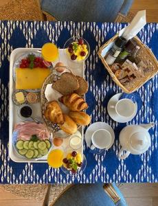 una mesa azul y blanca con comida y bebidas. en House of Cocagne, en Kockengen