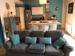 un soggiorno con divano e una cucina di Chambre privée Triel-sur-Seine a Triel-sur-Seine