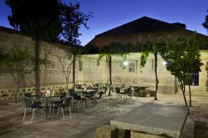 a patio with tables and chairs in front of a building at Parador de Almagro in Almagro