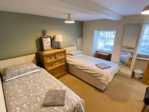 1 dormitorio con 2 camas, vestidor y ventana en The Stables, en Bakewell