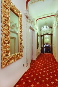 a hallway with a large mirror and a red carpet at Alisa Hotel in Karlovy Vary