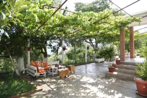een patio met een bos meubilair en bomen bij Guest House Bashaj in Bashaj