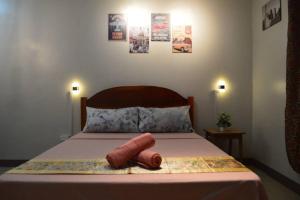 a bedroom with a bed with two objects on it at Dencio's Crib in Mactan