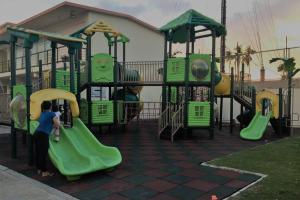 a child playing on a playground in a park at Dencio's Crib in Mactan