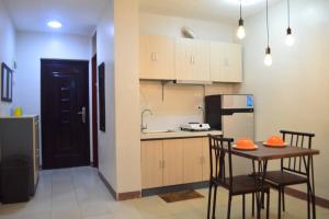 a kitchen with a table and chairs and a kitchen with a refrigerator at Dencio's Crib in Mactan +14 photos