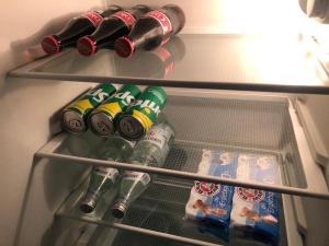 - un réfrigérateur rempli de boissons et de bouteilles de soda dans l'établissement Ferienwohnung Wohnung Krefeld Forstwald Höltehoffe, à Krefeld