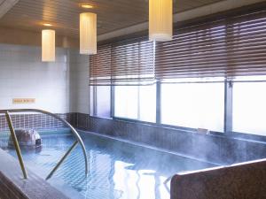 a swimming pool in a building with a pool at Dormy Inn Premium Kyoto Ekimae Natural Hot Spring in Kyoto