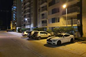 een rij auto's geparkeerd op een parkeerplaats 's nachts bij Confortable apartamento en conjunto Puerto Azul Club House in Ricaurte