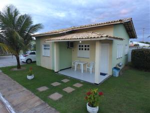 una pequeña casa con una mesa en el patio en CHALÉS ENCANTOS DA ILHA, en Barra dos Coqueiros