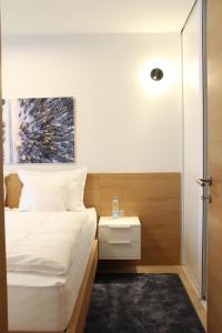 a bedroom with a white bed with a nightstand and a bed sidx sidx sidx at Apartment A605 - Olimpijska kuca Jahorina in Jahorina