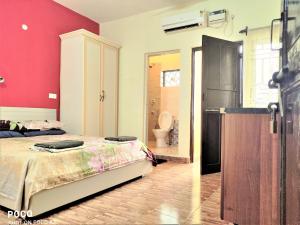 a bedroom with a bed and a bathroom with a toilet at Monte Villa Guest House in Candolim