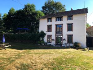 a white house with a picnic table in front of it at Moulin des Forges Gites, Camping et Glamping in Moutier-Malcard