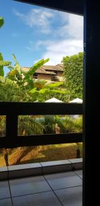 a window with a view of a house at Pousada Guaruja in Bombinhas