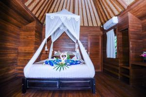 a bedroom with a bed with a canopy at Karang Mas Villa Nusa Lembongan in Nusa Lembongan