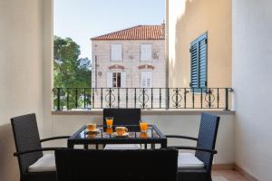 a table and chairs on a balcony with a view of a building at Apartment City Strand in Makarska