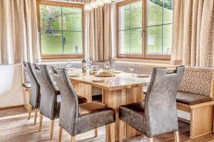 a dining room with a wooden table and chairs at Chalets Hotter Ferienhaus mit E-Ladestation in Zell am Ziller
