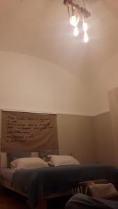Habitación con 2 camas y una luz en el techo. en Suite Re Riccardo, en Caserta