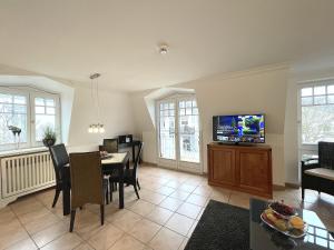 een woonkamer met een eettafel en een tv bij Suite Boysen No.15 in Westerland