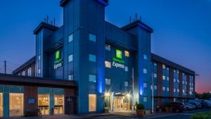 un edificio de oficinas con letreros verdes. en Holiday Inn Express Oxford Kassam Stadium, an IHG Hotel en Oxford