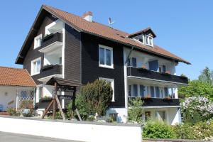 czarno-biały dom z kwiatami na balkonie w obiekcie Ulrichshof w mieście Braunlage